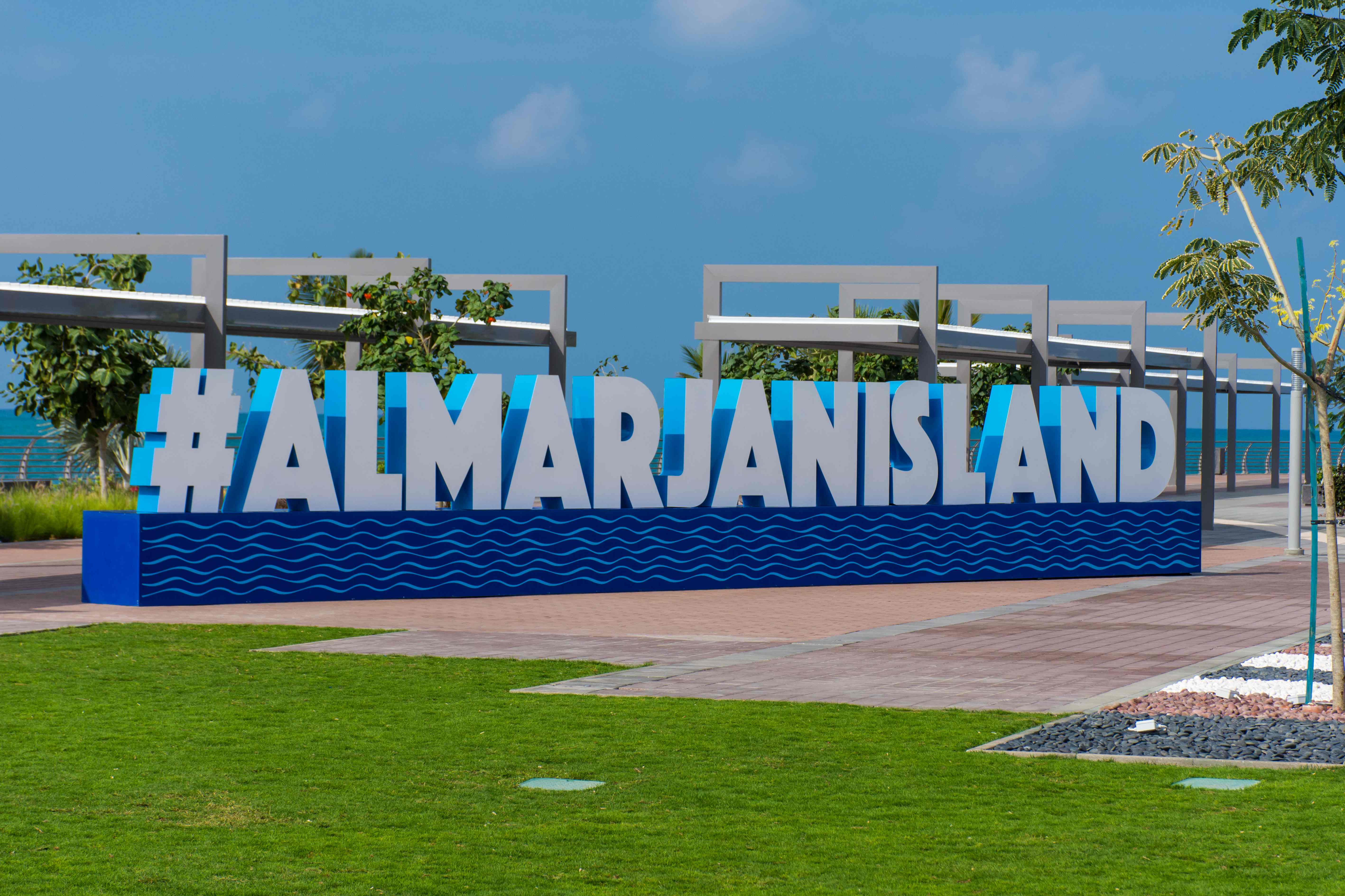 Al Marjan Island Landmark - Global Recognition Iconic #ALMARJANISLAND landmark sign with blue wave pattern at entrance of Al Marjan Island tourist destination in Ras Al Khaimah UAE